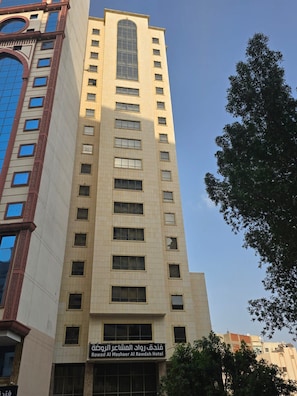 A tall hotel building with multiple floors and a sign indicating it is the Rowad Al Mashaer Al Rawdah Hotel. - Rowad Al Mashaer Al Rawdah Hotel (Makkah)