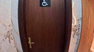 Una puerta de madera con un letrero de accesibilidad para sillas de ruedas.