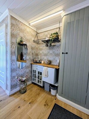 Un baño con suelo de madera, un espejo, un lavabo y un armario.