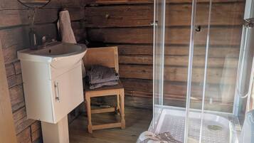 Et lille badeværelse med vask, toilet og brusebad.