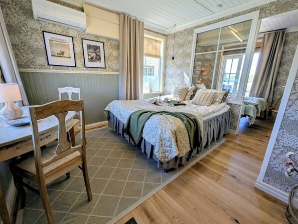 A bedroom with a bed, a desk, and a chair.