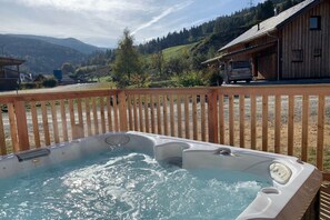 Ein Whirlpool mit einer Holterrasse in einer gebirgigen Gegend.