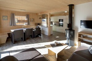 Ein gemütliches Blockhaus-Interieur mit Essbereich, Küche und Kamin.