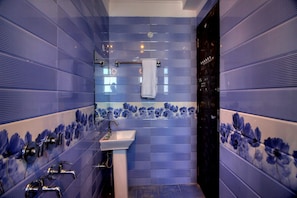 Une salle de bain avec un lavabo, plusieurs robinets et un espace douche.