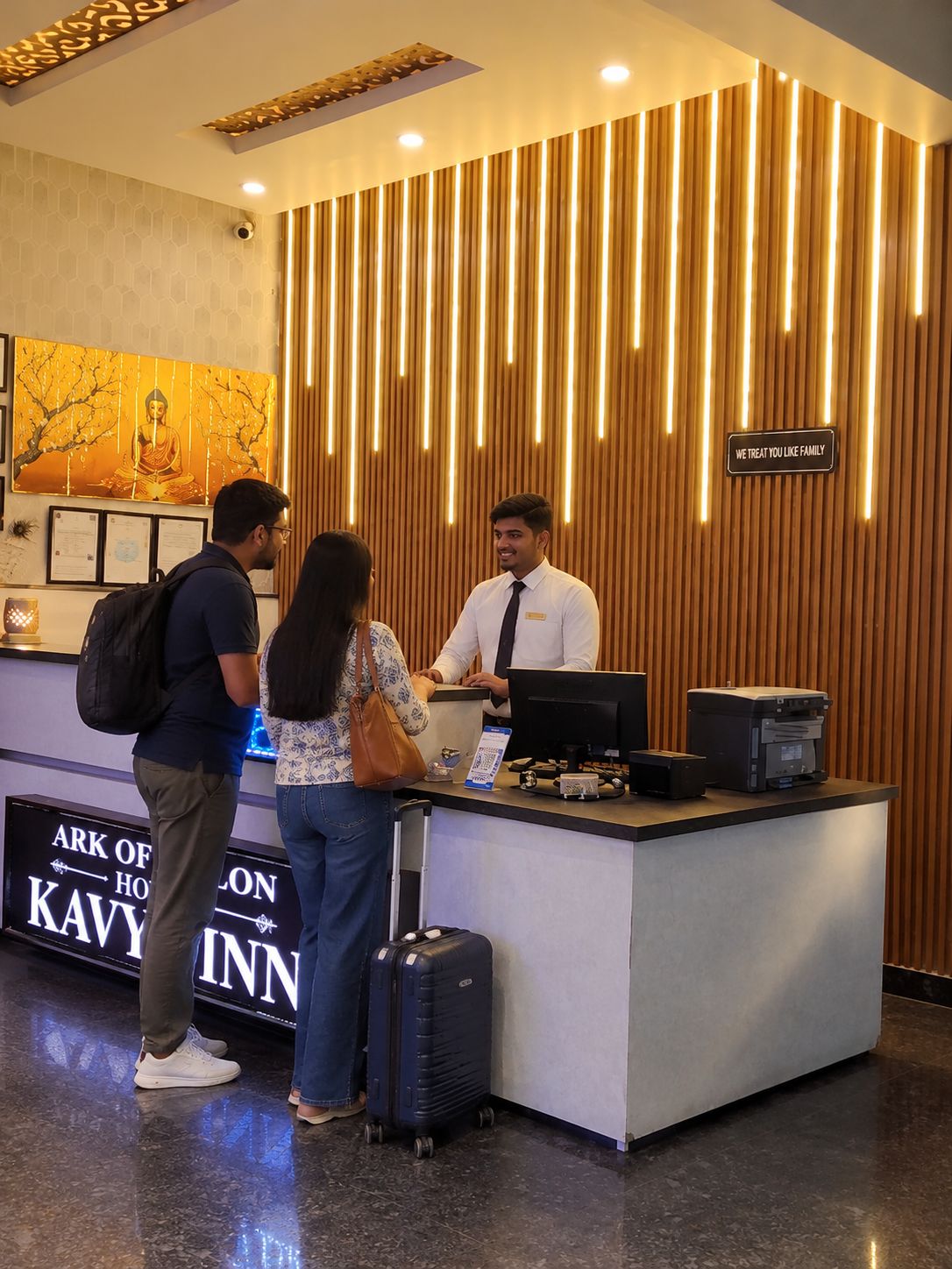 A reception desk with a wooden panel design and a sign that reads 'WE TREAT YOU LIKE FAMILY'.