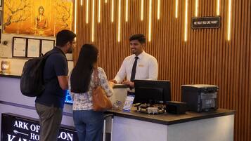 A reception desk with a wooden panel design and a sign that reads 'WE TREAT YOU LIKE FAMILY'.