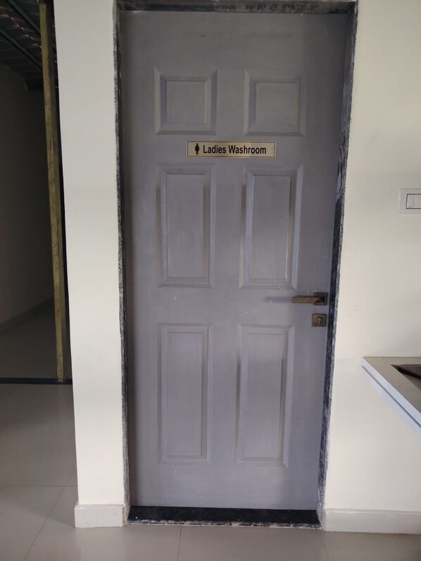 A door with a sign indicating a ladies' washroom.