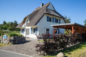 A two-story house with a thatched roof, a covered porch, and a stone wall. - ||------------------------Reed Warbler 48--------------------|| (Fuhlendorf)