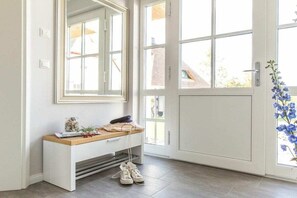 A clean, modern entryway with a white console table, a mirror, and a door with large windows. - ||----------------------------Reed Warbler 36-----------------------|| (Fuhlendorf)