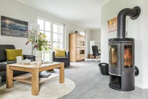 Ein modernes Wohnzimmer mit Kamin, einer Couch, einem Couchtisch und einem Bücherregal.