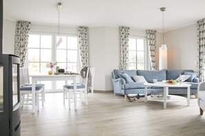Ein Wohnzimmer mit einer Couch, einem Couchtisch und einem Essbereich mit Stühlen.