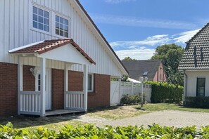 A single-story house with a porch, a brick exterior, and a tiled roof. - Holiday home in Bastorf with swimming pool (Bastorf)