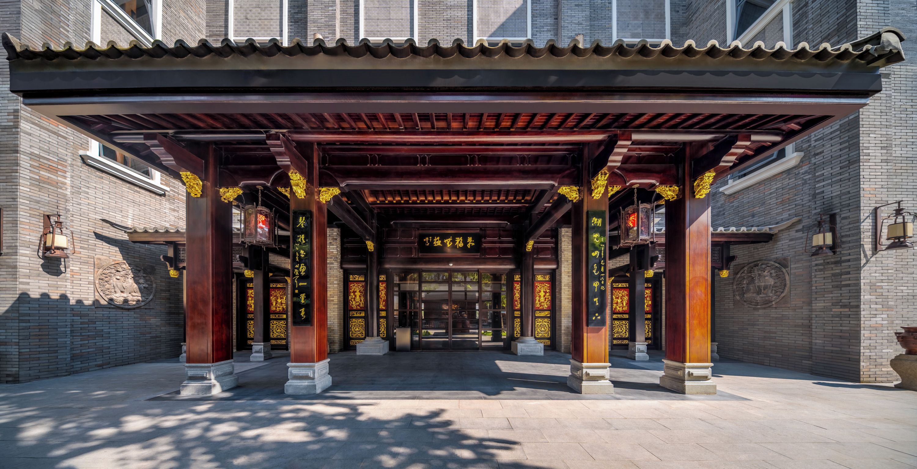 A traditional Chinese architectural entrance with wooden pillars and intricate designs.