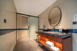 A modern bathroom with a large mirror, a wooden vanity, and a shower area. - Shili Huating Hongpu Hotel (Guangzhou)