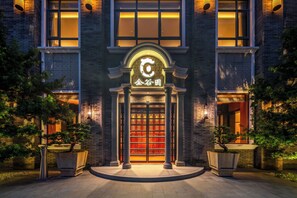 Un edificio de estilo arquitectónico chino tradicional, con una entrada destacada que incluye un arco decorativo y un letrero iluminado.