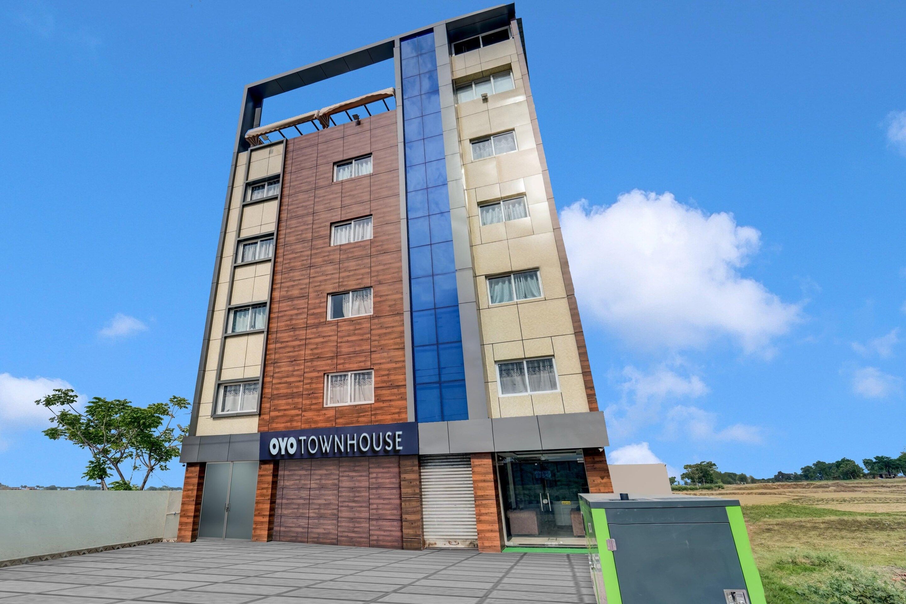 A multi-story building with a sign reading 'OYO TOWNHOUSE.'
