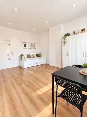 A modern interior with a dining table, chairs, a sofa, and a cabinet with plants. - Vrbo Property (Marseille)
