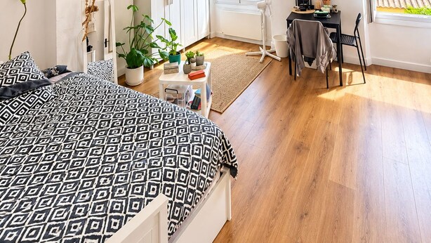 Ein Schlafzimmer mit einem Bett, einem Schreibtisch und einem Fenster.