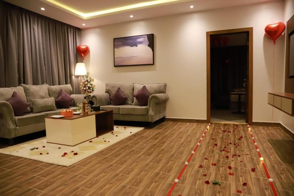 A modern living room with two sofas, a coffee table, and a decorative arrangement of rose petals and candles.