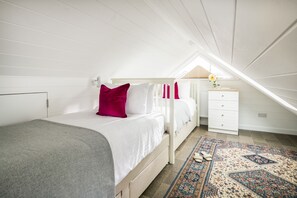Ein Schlafzimmer mit einem Etagenbett, einem Nachttisch mit einer Vase und einem gemusterten Teppich.
