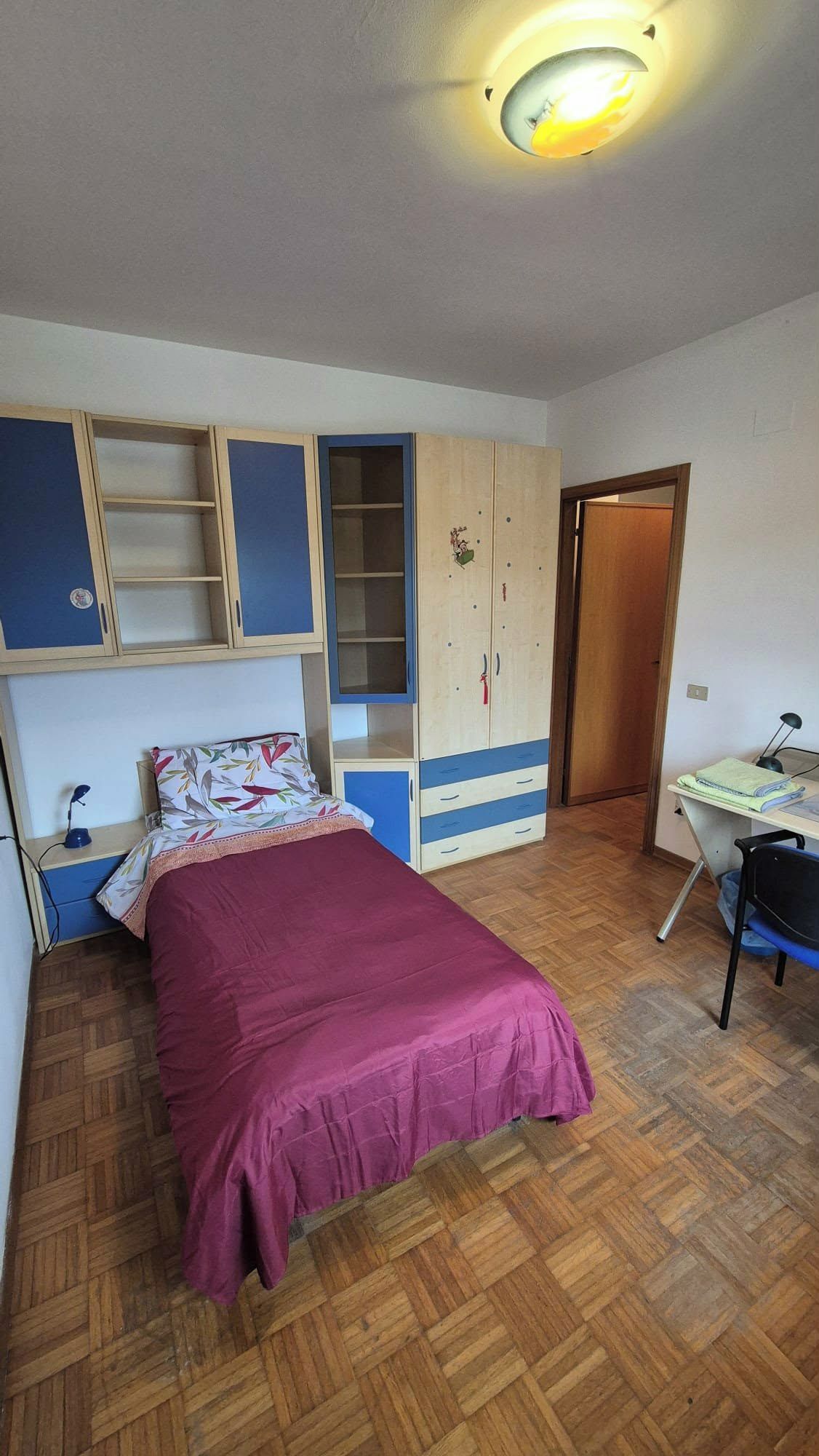 Ein Schlafzimmer mit einem Bett, einem Schreibtisch und einem Kleiderschrank.