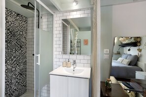 Une salle de bain moderne avec une douche, un lavabo et un miroir.