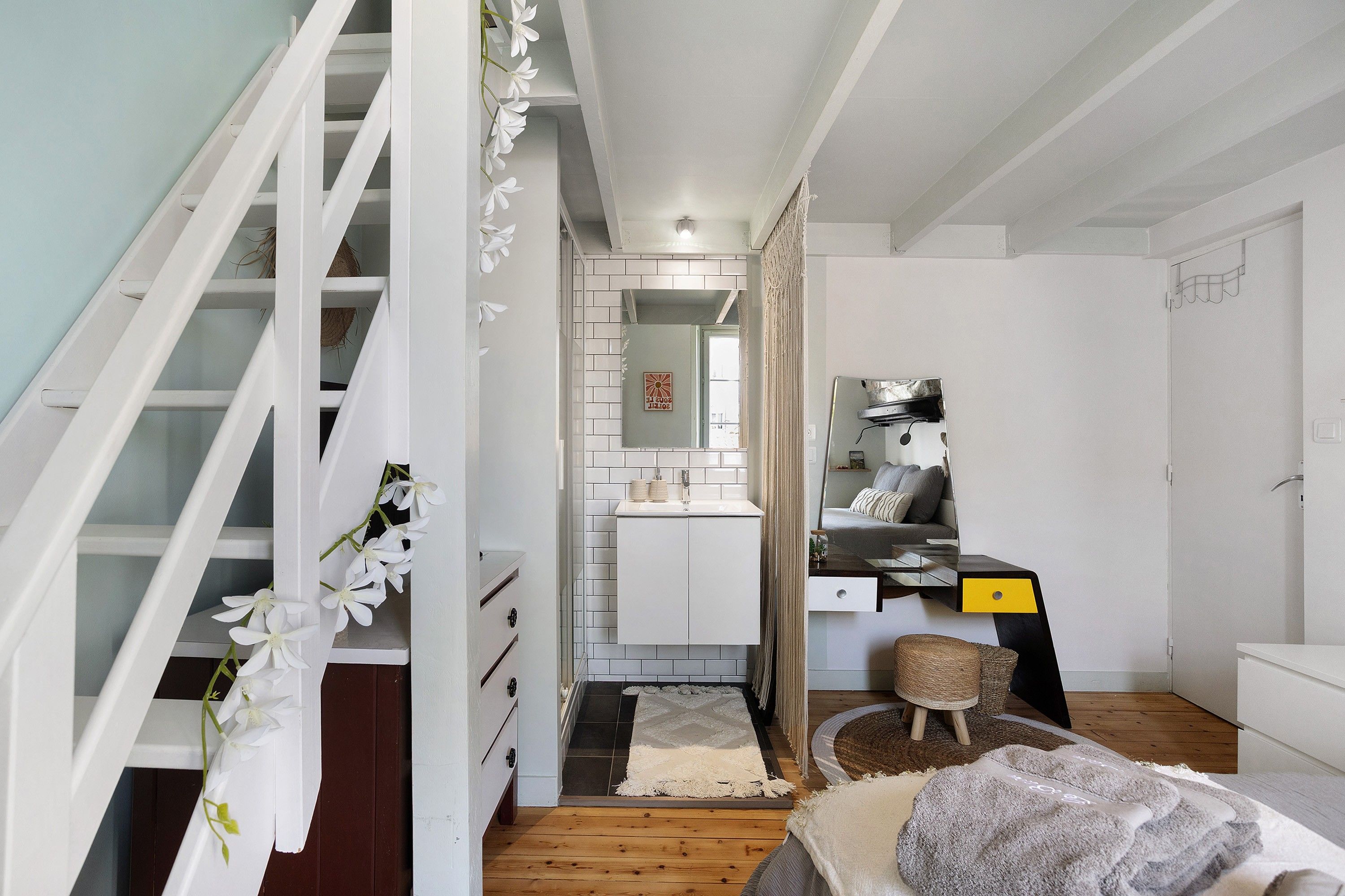 Ein modernes Interieur mit Treppe, Küchenbereich und einer Sitzecke mit Teppich.