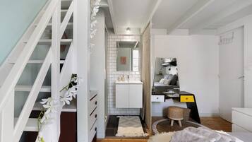 Ein modernes Interieur mit Treppe, Küchenbereich und einer Sitzecke mit Teppich.