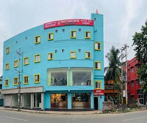 Un immeuble à plusieurs étages, doté d’une façade bleue et de cadres de fenêtres jaunes, sur lequel on peut voir une enseigne indiquant « Knight Guest House Hotel The Knight » et, au rez-de-chaussée, un restaurant appelé « Croesinc Point Restaurant ».