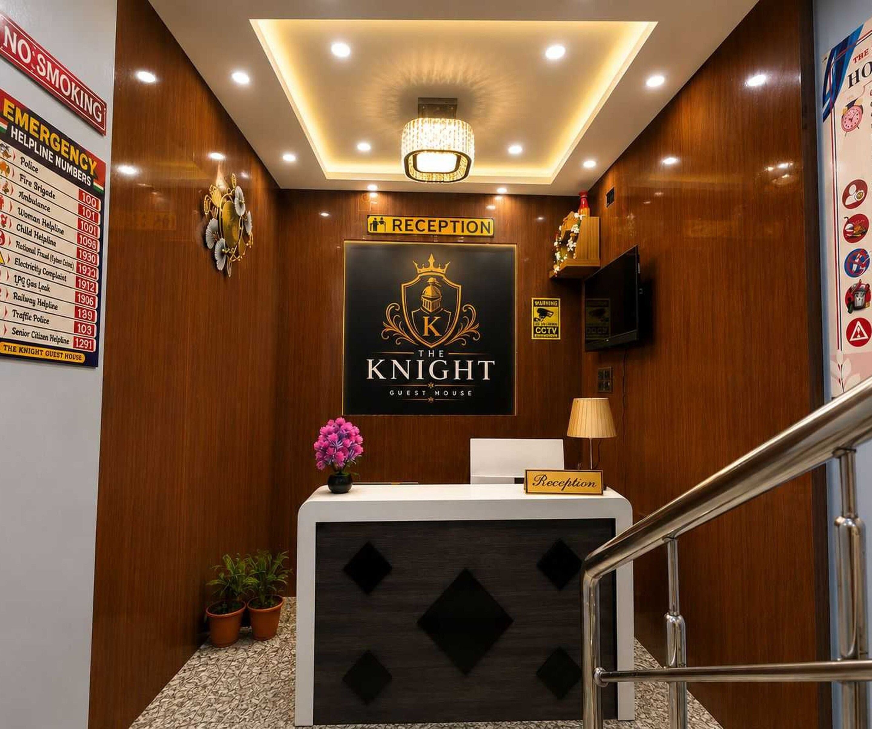 En receptionsdisk med et skilt der siger 'RECEPTION' over, et 'NO SMOKING' skilt til venstre, og et skilt der siger 'THE KNIGHT GUEST HOUSE' over disken.