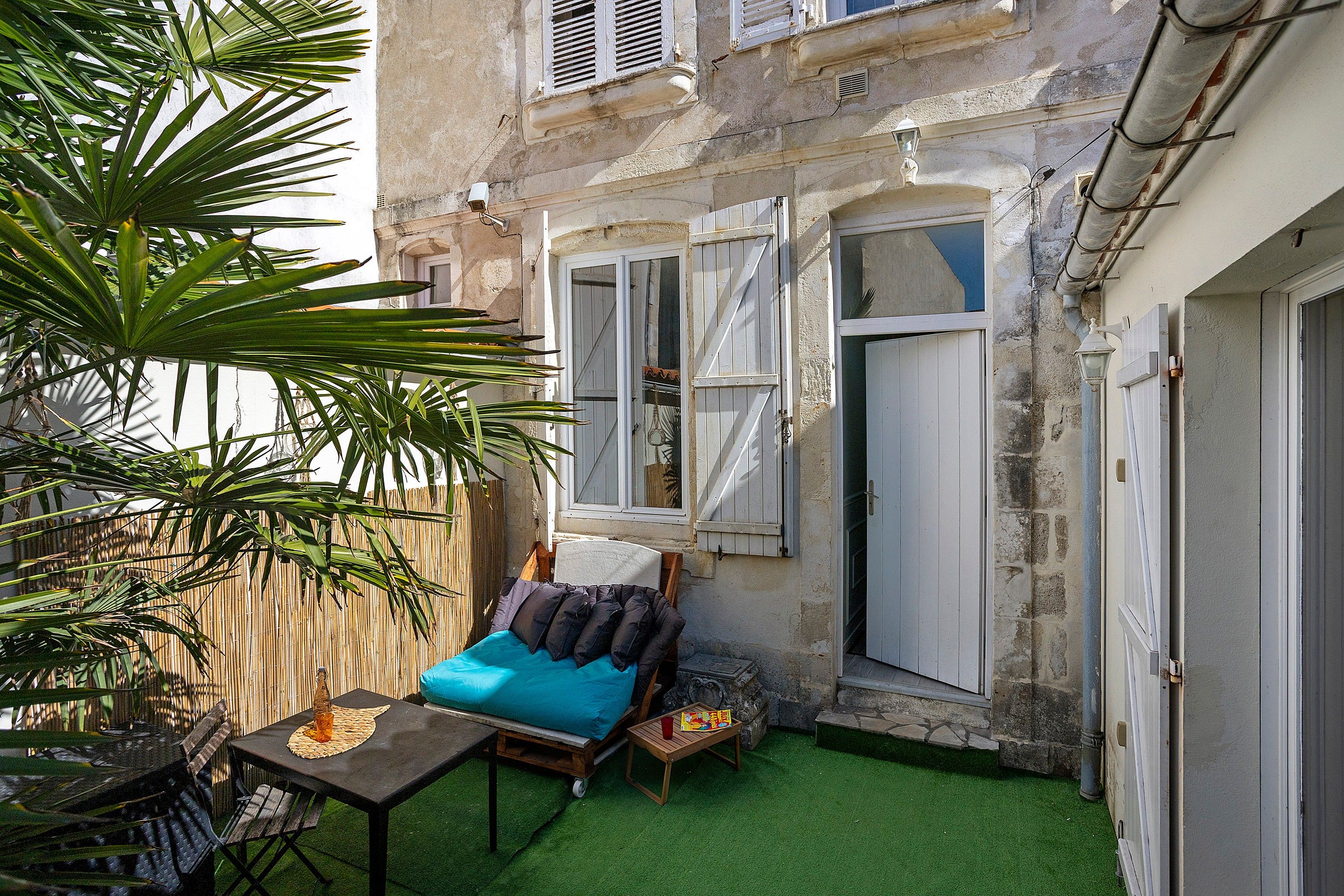 Un petit espace extérieur aménagé avec une table, des chaises et un canapé.