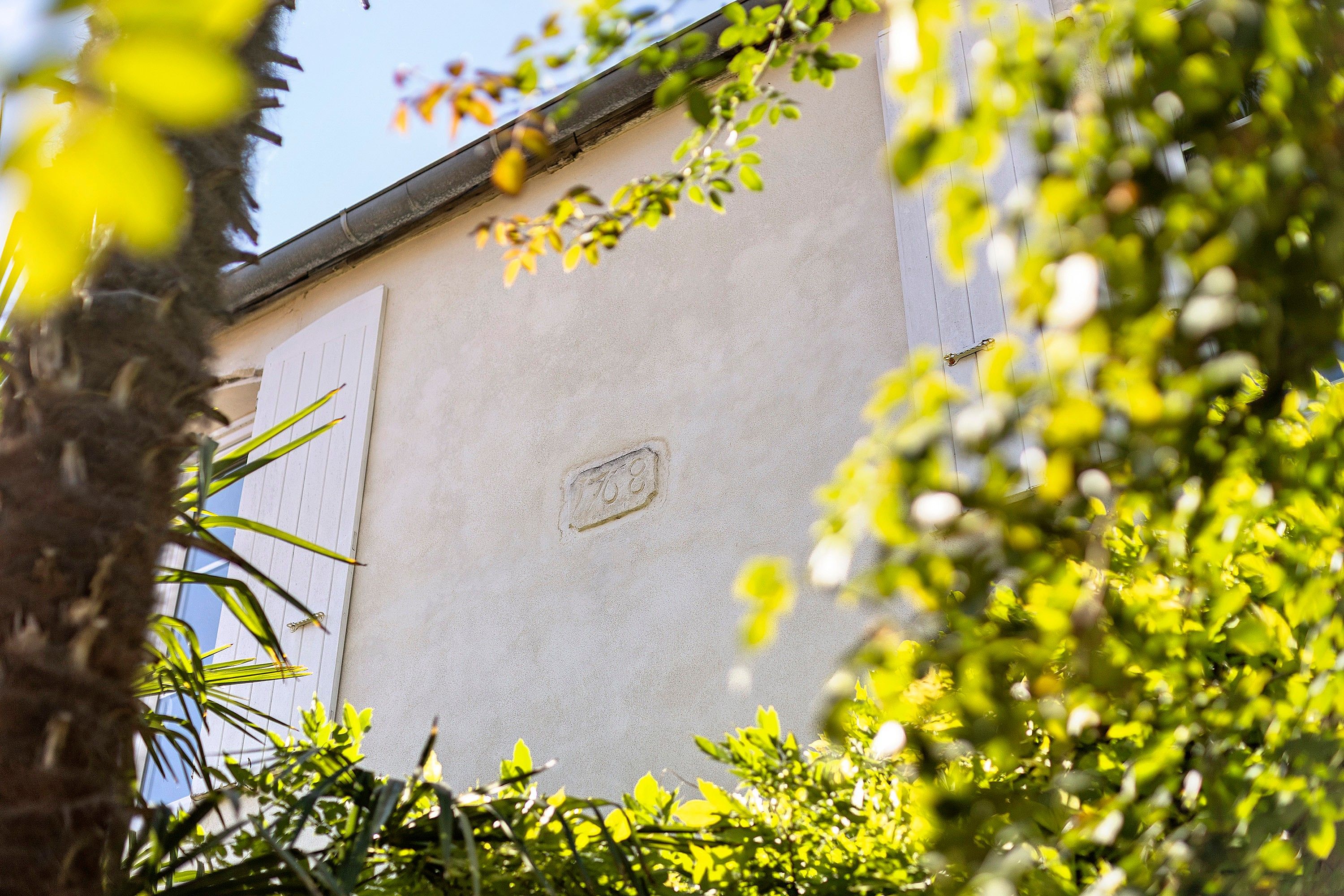 Une façade d’immeuble avec une plaque indiquant l’adresse et une fenêtre.