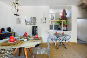 Una zona de menjador amb una taula rodona, cadires i un mirall decoratiu.