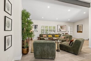 A spacious living room with a sofa set, a coffee table, and a large potted plant. - This house is a 3 bedroom(s), 2 bathrooms, located in Scottsdale, AZ. (Scottsdale)