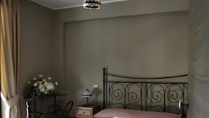 Une chambre à coucher avec un lit en métal, un luminaire suspendu et une table de chevet avec une lampe.