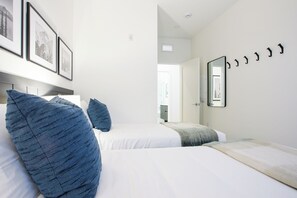 Ein Hotelzimmer mit zwei Betten, einem großen Spiegel und gerahmten Bildern an der Wand.