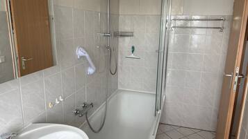 Un baño con bañera, ducha y lavamanos.