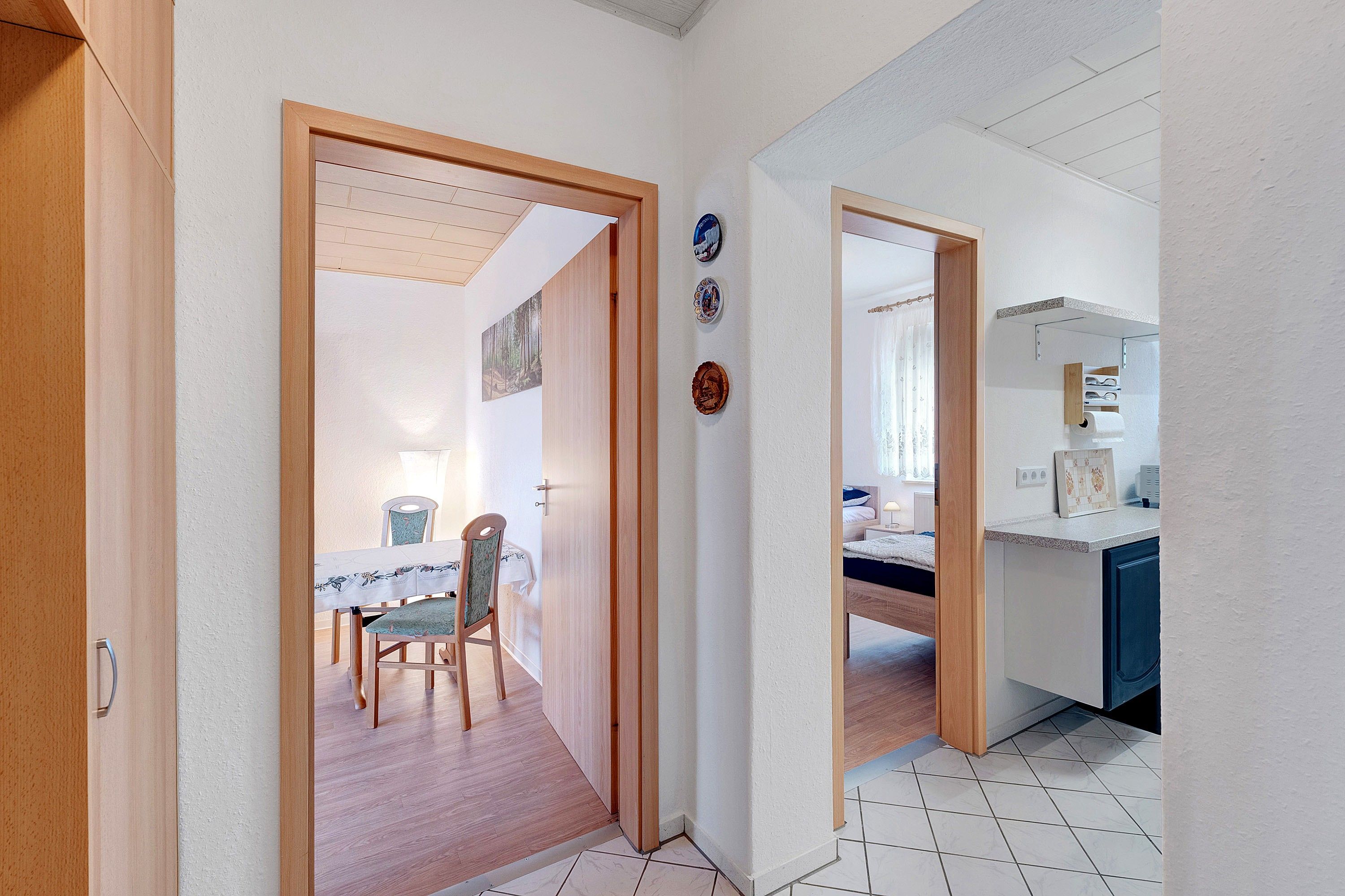Un pasillo con comedor, cocina y baño.