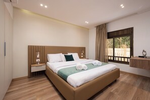 A hotel room with a large bed, a bedside table, a nightstand, a window with curtains, and a view of the outdoors. - Cozy Corner at Elevens by spacey #27 (cairo)