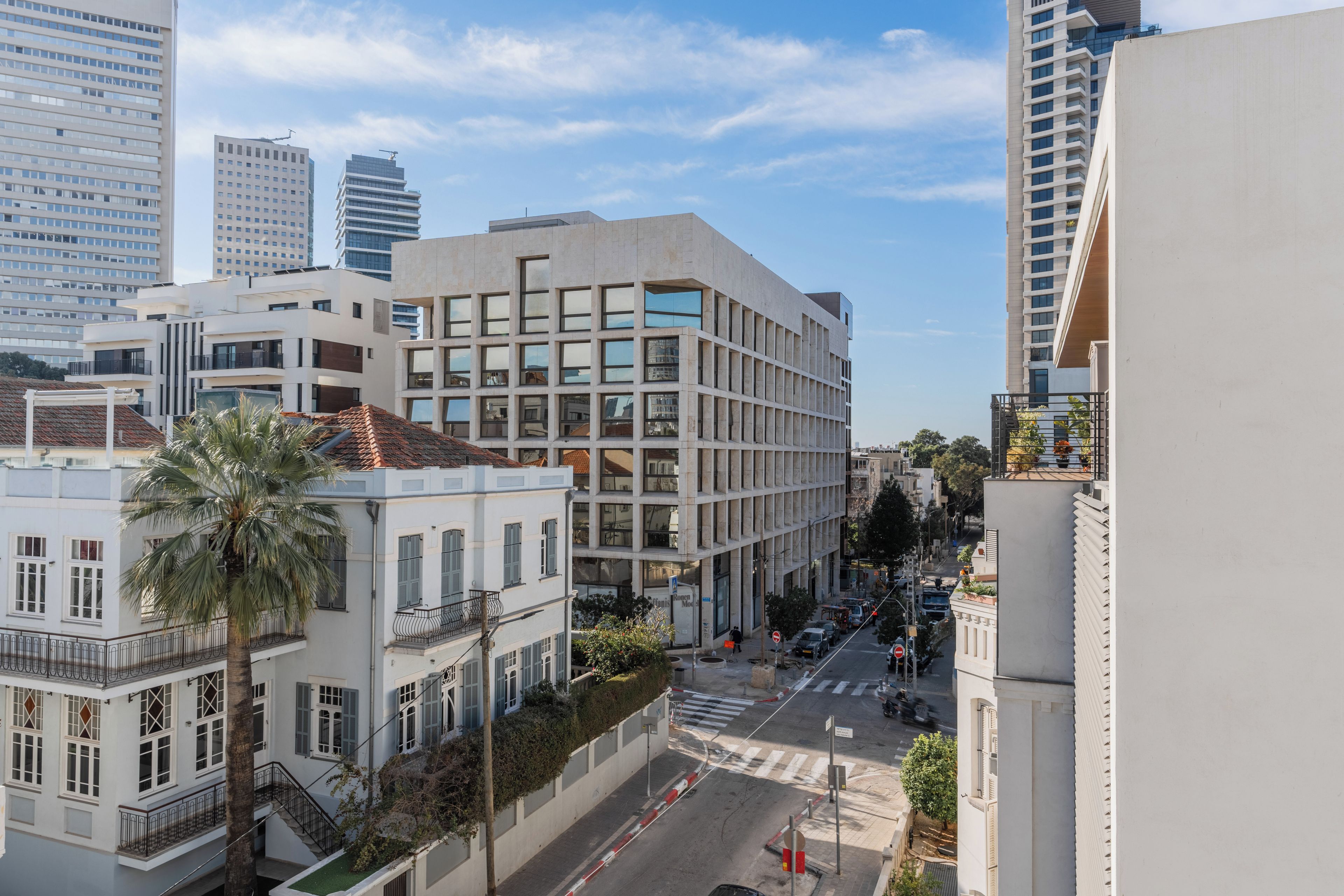 A multi-story building with a modern architectural design, featuring a mix of glass and concrete facades.