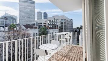 Een balkon met uitzicht op een stadsgezicht, met moderne gebouwen en een heldere lucht.