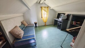 A compact room with a bed, a small desk, a television, and a keyboard. - Beautiful vacation villa 🌴 (Le Tampon)