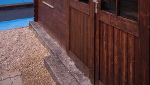 A wooden cabin with a sign reading 'les tiots Picards' and a pool in the background. - Vrbo Property (Brutelles)