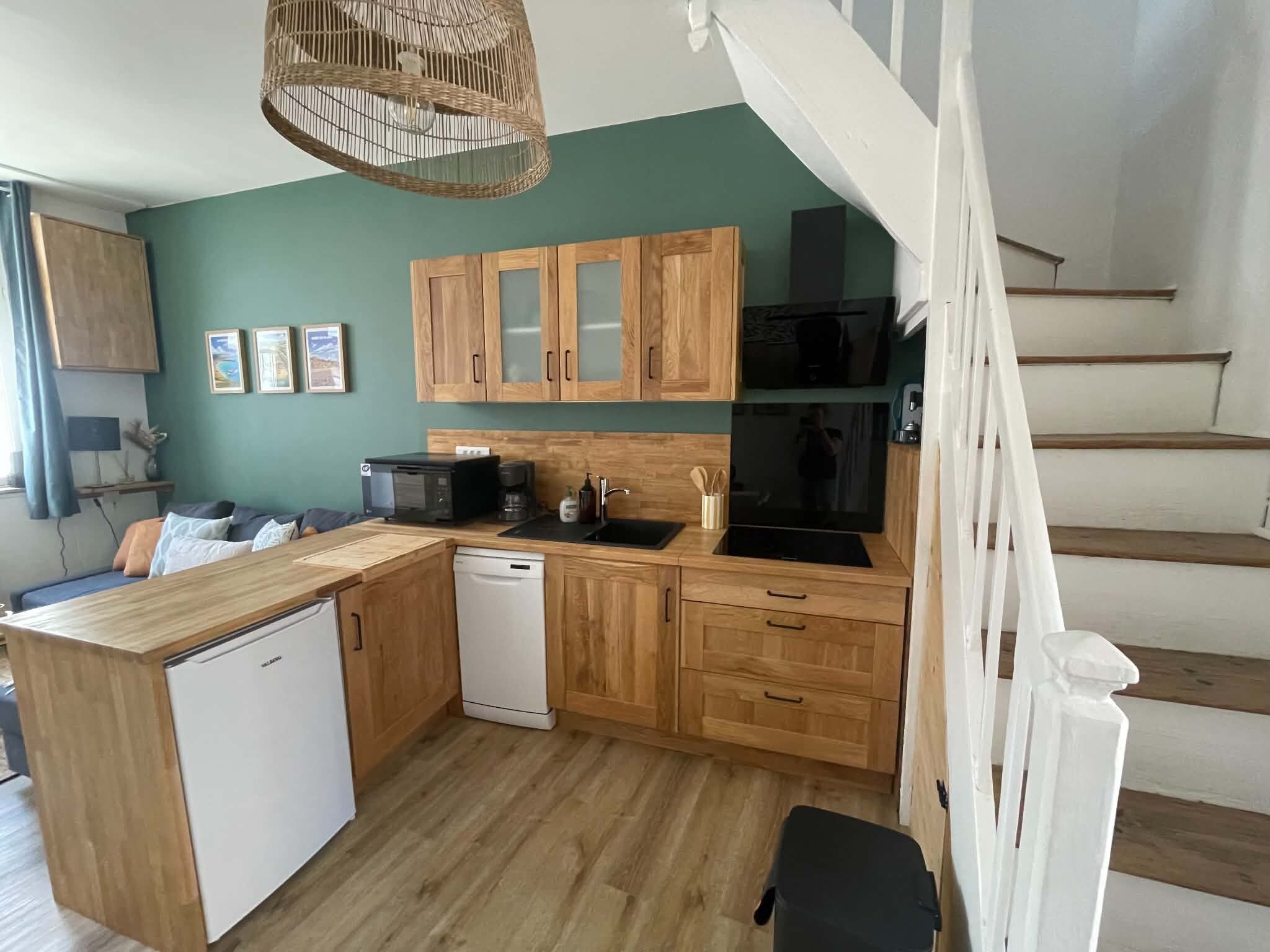 A compact kitchen with wooden cabinets, a dishwasher, and a microwave.