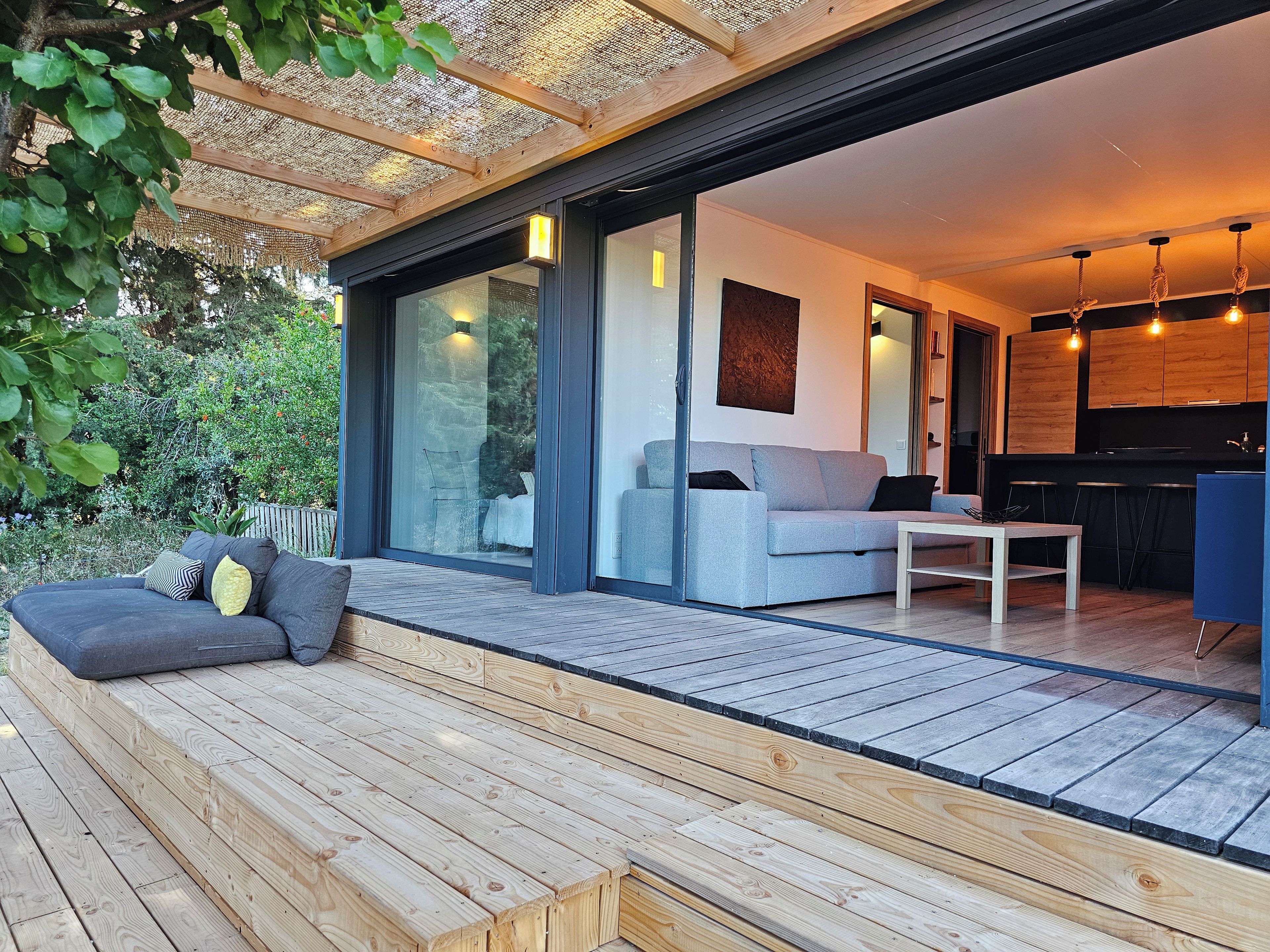 A modern interior with a sofa, a dining table, and a kitchen area.