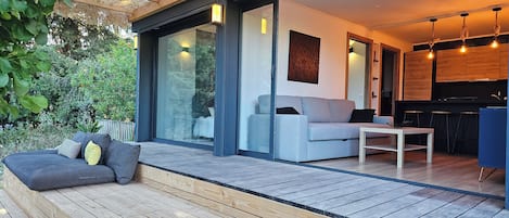 A modern interior with a sofa, a dining table, and a kitchen area.