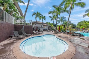 Ein Pool mit Liegestühlen und Palmen.