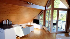 A modern kitchen with wooden ceiling, large windows, and a view of greenery. - Vrbo Property (Freiburg im Breisgau)