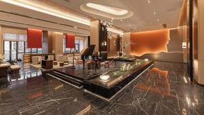 Eine moderne Lobby mit einem Flügel, einer Sitzecke und einer Rezeption.