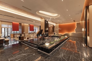 Eine moderne Lobby mit einem Flügel, einer Sitzecke und einer Rezeption.
